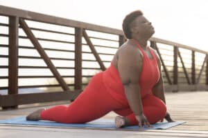 An African American woman working out outdoors as a form of self-love.